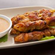 カレーやウコンに漬け込んだ鶏もも肉を、芳ばしくジューシーに焼き上げてあります。ココナッツとビーナッツがたっぷり入ったマイルドな味のソースに付けて食べる、人気の逸品です。