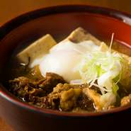 たっぷりの牛すじを大き目のお豆腐と共に、丸一日じっくりと煮込みました。温泉卵もはいってボリュームたっぷり！濃厚で甘辛い味わいが後を引くリピート間違いなしの逸品です。　