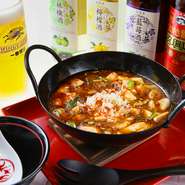 豆腐店から仕入れたソフトな絹ごし豆腐を1度塩ゆでして締めてから、山椒を効かせた味付けに仕上げたこだわりの麻婆豆腐です。皿ではなく小さな中華鍋に盛り付けるので、熱々のまま食べる事ができます。