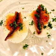 自家製の半熟卵は絶妙なとろけ具合。半熟卵のまろやかさとアンチョビの塩味がマッチした当店の人気おつまみメニュー。