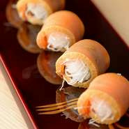 カジキ鮪の脂ののった部分を使い、一晩かけてしっかり味を入れます。大根のけん（千切り）と海苔、たっぷりの山葵を巻いた創作系のおつくりです。「カジキのヅケ」には、キレのある飲み口の日本酒がおすすめです。