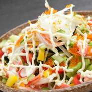 葉物野菜と玉ねぎ、きゅうり、パプリカなどの生野菜にズワイガニと飛子を合わせ、自家製ドレッシングとマヨネーズで。前菜として楽しまれるお客様が多い人気のサラダです。