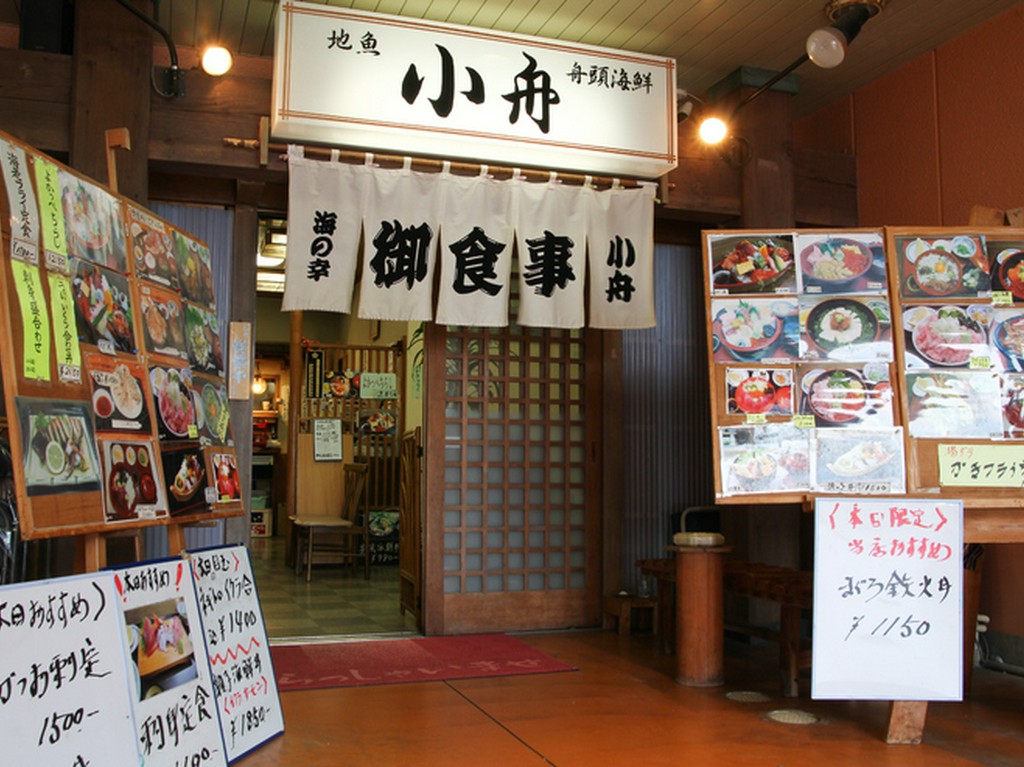 趣きのある暖簾と食欲を刺激する写真があるエントランスが目印