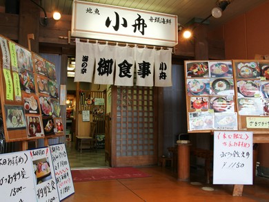 趣きのある暖簾と食欲を刺激する写真があるエントランスが目印