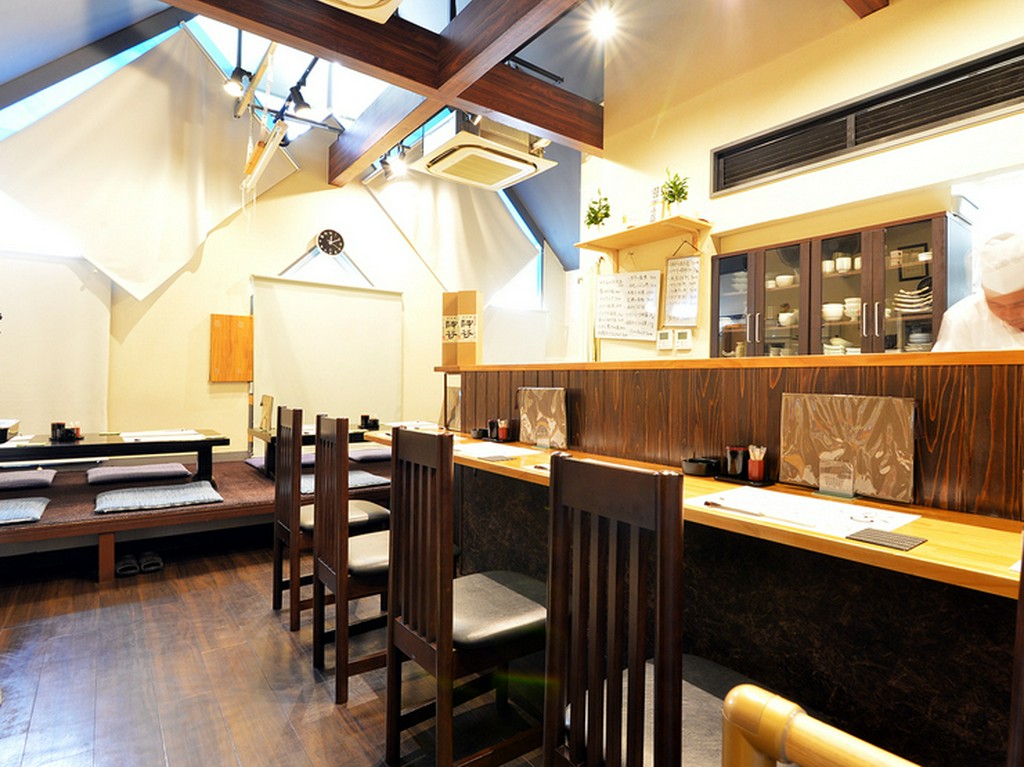 吹き抜けの天井が開放感を醸す、全13席のこじんまりとした店内