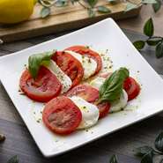 テイクアウトOK フレッシュなトマトとモチっとしたモッツァレラチーズにバジルソースをかけた本格イタリアンな一品です。