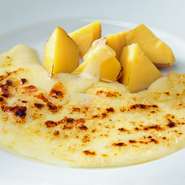 名物『ラクレットチーズ』は、専用ヒーターで炙る大人気メニューです。使っているのは、非加熱処理されたフランス産のチーズ。きれいな焼き色がつくのはそのためなのです。