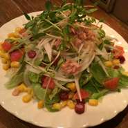 レタス、タマネギ、ツナ、コーン、サラミ、トマトが入った食べごたえがあるサラダ。