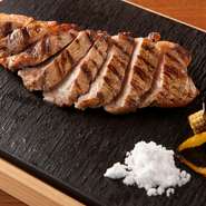 宮崎県の焼酎蔵元「黒木本店」の焼酎廃液からつくった飼料を与え、黒豚に匹敵する旨味を湛えた「あじ豚」。素材の味を堪能できるようシンプルに焼き上げ、甘みを引き出す天然塩で。