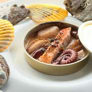 鳥取県は境港から仕入れたキンメダイや水ダコなどをはじめ、魚介類をふんだんに使った煮込み料理です。シチリアで修業したレストランのスペシャリテで、遊び心で缶詰に盛り付けてみました。