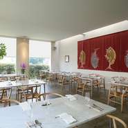 シンプルにまとめた内装。とはいえテーブルには大理石、椅子は座り心地を考慮したワイチェアを使うなど、こだわりのある設え。ゆとりを持たせた席の配置は、食事をゆっくり味わえるようにとの配慮です。