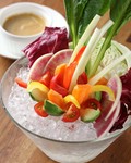 農園から直送されるカラフルな瑞々しい新鮮野菜を華やかに盛り付けた一品です。ニンニクやアンチョビ、生クリームと味噌を使い風味豊かに仕上げた自家製ソースでいただきます。