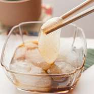 わらびもち粉を、注文を受けてから練り上げています。こだわりは、気泡が見える透明感と、箸でつまめるぎりぎりの柔らかさ。黒豆きな粉をつけていただくやさしい味のスイーツです。