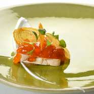 脂が溶けないようにゆっくりと火を入れるフォアグラを、奈良県産の代白柿と甘柿のチップスをのせて。 ピューレにしたレーズンとヨーグルトのソースで。