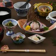 愛媛県・宇和島を代表する郷土料理。生の鯛の身と冷たい出汁をアツアツのご飯にかけて食べる宇和島ならではの宇和島鯛めし・日替わり小鉢・炊き合わせ・お漬物の御膳をお楽しみください。