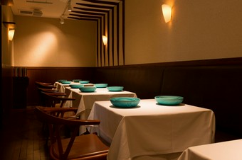 エメラルドグリーンの位置皿が浮かび上がるシンプルな空間