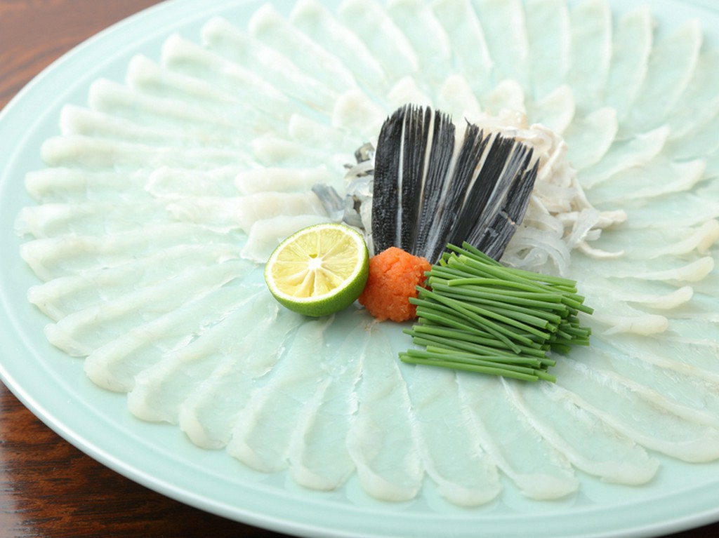 季節の柑橘を絞ってつくる自家製ポン酢と薬味を添えて。独特の歯ごたえが美味しい『養殖とらふく刺身』　