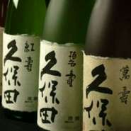 （燕三条ぐい呑み（受け皿付）120cc1400円、徳利180cc2070円）写真は、ぐい飲み（受け皿付）の日本酒。全種類の「久保田」がいただけるほど種類豊富な品揃えです。60ccから味わえるので、試し飲みにも最適。