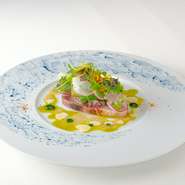 コースの幕開けを清々しく彩る前菜。北海道戸井産の天然ブリを瞬間燻製し、風味豊かに仕上げているのが特長です。春菊のピューレ、タブナード、エシャロット、サワークリームが絡み合い、ブリの旨みを引き立てます。