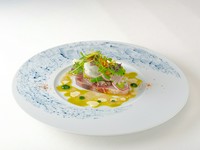 コースの幕開けを清々しく彩る前菜。北海道戸井産の天然ブリを瞬間燻製し、風味豊かに仕上げているのが特長です。春菊のピューレ、タブナード、エシャロット、サワークリームが絡み合い、ブリの旨みを引き立てます。