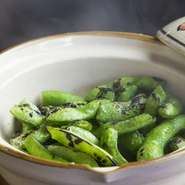 土鍋で蒸し焼きにして、ほんのり焼き色を付けた枝豆です。凝縮されたうま味や食感を楽しめる人気の一品。