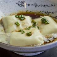 絹ごし豆腐を使い、やわらかに仕上げたやさしいお味。特製醤油だれをかけて供されます。