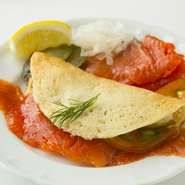 当店の伝統料理。自家製の生サーモンのフレッシュマリネを、薄焼きのブイヌイパンケーキに包んで召し上がっていただく前菜です。