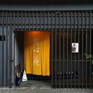 住宅や店舗が立ち並ぶ小路に沿ってひっそりと佇んでおり、店先では明るく映える暖簾が風に揺れています。風流な格子戸をくぐり、店内へ。暖簾の奥には、雅な空間が広がります。