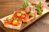 北海道のブランド小麦「春よ恋」を使用。もちもちで焼きあがった時の香りが食欲をそそります。マルゲリータ／アンチョビトマト等から各種2個を選んで注文でき、オリーブの木の温かみにも和みます。