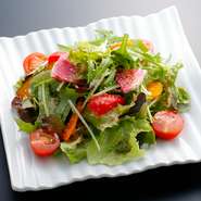 新鮮野菜に白ワインビネガーを使用した絶品ハニーマスタードドレッシングを和えました。糖度の高いフルーツトマト、黄色人参、紅芯大根等食材もこだわった主力のサラダです。