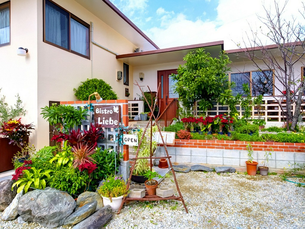 可愛らしい看板とハーブなどの草花が出迎える一軒家レストラン