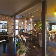 ドアを開けると、まず目に飛び込んでくるのがグランドピアノ。木を基調としたインテリアが居心地のいい空間をつくり出しています。座席はゆったりと配置されており、グリーンの観葉植物を随所に配しています。