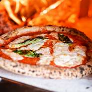 イタリア産の小麦粉と、水、塩、酵母だけでこね、12時間発酵させてつくる生地は、ナポリピッツァ特有のモチモチとした食感が自慢。450度の薪窯で、1分で焼き上げます。鼻からぬける小麦粉の香りを体感してください。