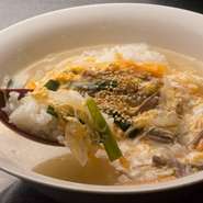 金賞を受賞した熱々のお米を、一昼夜煮込んだテールを素にしたスープで雑炊仕立てに。テール肉や野菜が加えられており、創業当時からある深みのある味わいがヤミツキになります。