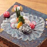 料理人の卓越した包丁技術が料理の旨みや美しさを引き立てます。繊細な技が光る『ふぐ料理』の『てっさ』は下の皿が透けて見える美しさ。洗練された料理は大切な人をもてなす接待の場にもぴったり。