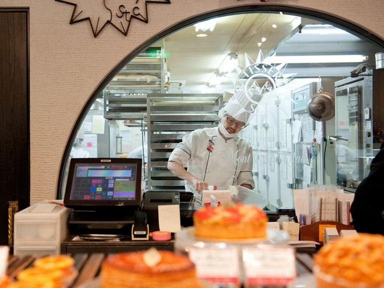 パティシエがスイーツをつくる姿が見えるガラス越しの厨房