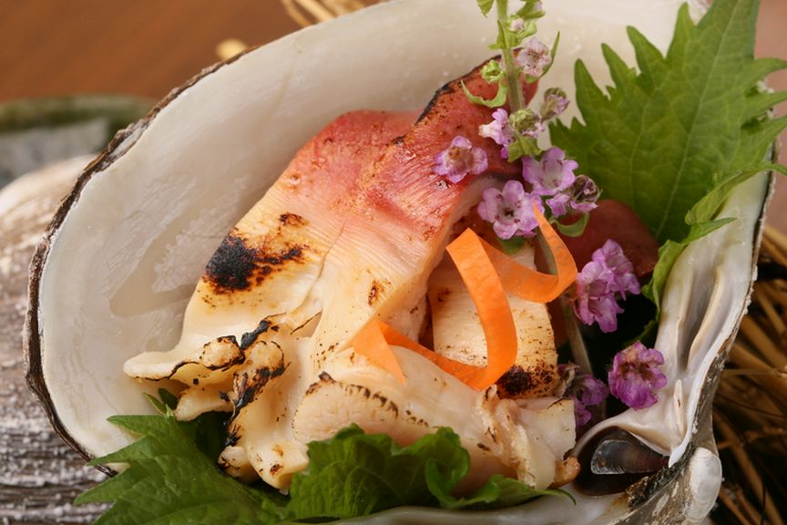 炭の香りをまとい、刺身と違う味わいを楽しむ『活北寄の炙り すだちと塩で』