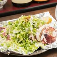 イカを丸々鉄板で炒め、ホワイトソースをかけた上に大量のネギをのせて、ポン酢でいただきます。ポン酢の酸味、ネギの爽やかな風味でさっぱりとしているので、ボリュームあってもペロッと食べられる逸品です。