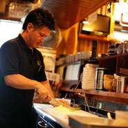 オープンキッチンなので接客もします。初めてのお客様でもくつろいで楽しい時間を過ごしていただけるよう、その方の好みに合わせた距離感を大切にしています。