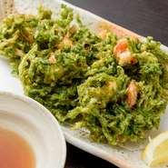 地元産の生アーサと海老を合わせたかき揚げ。天然のアーサは肉厚で大きく、栄養価の高い人気食材。濃厚な磯の香りとエビの甘み、そしてサクサクとした食感を楽しめる、まさに沖縄を凝縮したような一品です。