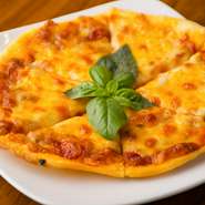 トマトとモッツァレラチーズに、バジルをあしらったシンプルかつ深い味わいのピザ。ピザ生地はお店の自家製で、薄くて軽い、パリッとした食感。赤ワインのおつまみとして食べると、相性抜群です。