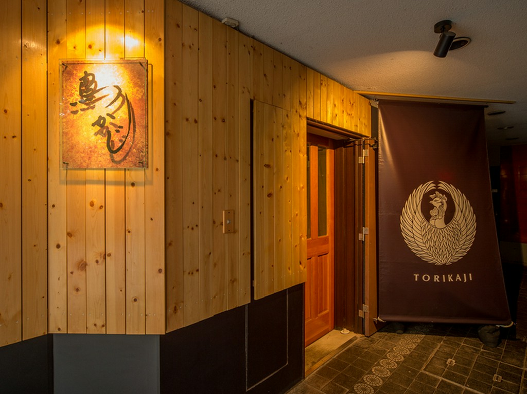 モダンな看板と鳳凰のような鶏のイラストが目印