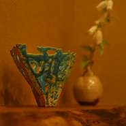 カウンターは桜の木の一枚板、土壁を背景に活けられているのは季節を感じさせる花。木と土をイメージし、温かみのある非日常の空間が施されています。京都らしい奥ゆかしさが魅力。