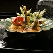 6～7月くらいまで食べられる稚鮎を味噌田楽でいただきます。白味噌と赤味噌、胡麻ペーストを合わせて練り上げた味噌が美味。天婦羅にされた稚鮎は、頭から尾まですべて食べられます。