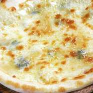 タレッジョ・ゴルゴンゾーラ・マリボ・ゴーダチーズをのせて焼き上げたピッツァ。お好みで蜂蜜をどうぞ。