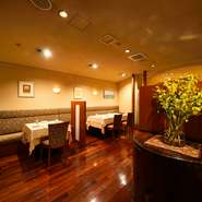 メインフロアのテーブル席はパーテーションで区切った広々とした空間。半個室のような感覚でくつろげます。床材のカリン材が醸し出す温かみも魅力のひとつ。食器はヨーロッパの名陶のものをそろえています。