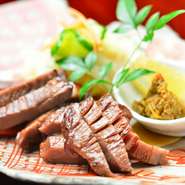 仙台名物牛タンも、自慢の自家製麹で旨味を増しているのが【古傳　小林】流。麹の作用でやわらかく仕上がるため、厚切りでたっぷりと味わえます。地酒とともに。