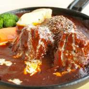 特製のデミグラスソースでじっくりと煮込み、一晩以上寝かせて完成。肉が一段と柔らかく、濃厚なソースで味わえます。