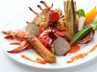 まるごと1尾を味わえるよう、旨みが濃い小ぶりのオマールエビを厳選し、半生加減にロースト。エビの卵でつくったコライユソースとともに、やわらかくまろやかな身を堪能できます。旬の野菜のおいしさも絶品です。