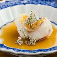 新鮮な甘鯛の身は、ていねいに蒸すことでやわらかくふっくらとした食感が楽しめます。さらに、鱗に高温の油をかけることでサクッとした食感も。パクチーの花が華やかさもプラスします。